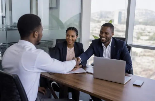 Candidate shaking hands with interviewers in a Lagos office